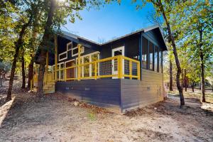 ein Haus im Wald mit gelbem Geländer in der Unterkunft Holly Lake Ranch Retreat in Rhonesboro