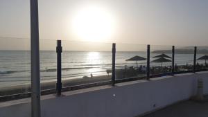 a view of a beach with umbrellas and the ocean at Apartment am Meer mit Pool in Aourir