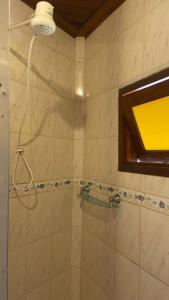 a bathroom with a shower with a window at Casa da Si Suítes & Hostel in Ubatuba