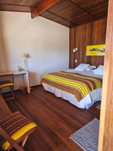 a bedroom with a bed and a desk in a room at Maktub Lodge - San Pedro de Atacama in San Pedro de Atacama