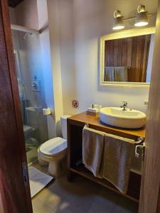 a bathroom with a sink and a toilet and a mirror at Maktub Lodge - San Pedro de Atacama in San Pedro de Atacama