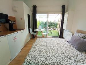 a bedroom with a bed and a kitchen with a table at Domaine Le Clos Lassagne in Brignais