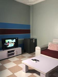 a living room with a tv and a coffee table at Residence MaryHouse in Cotonou