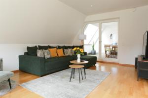 a living room with a green couch and a table at FAWAY Altstadt mittendrIN - einzigartiges Flair - Parken in Ingolstadt