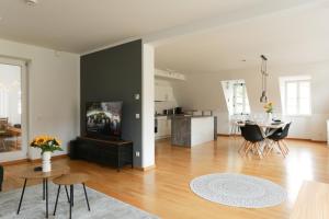 a living room with a table and a kitchen at FAWAY Altstadt mittendrIN - einzigartiges Flair - Parken in Ingolstadt