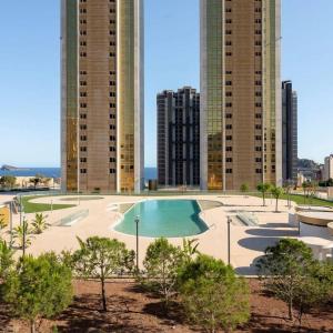 una piscina di fronte ad alcuni edifici alti di Intempo Residential Sky Resort & Spa - Benidorm, España a Benidorm