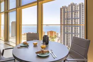 una sala da pranzo con tavolo e 2 bicchieri di succo d'arancia di Intempo Residential Sky Resort & Spa - Benidorm, España a Benidorm