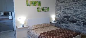 ein kleines Schlafzimmer mit einem Bett und einer Steinmauer in der Unterkunft Paradise Santo Amaro II in Ponta do Sol
