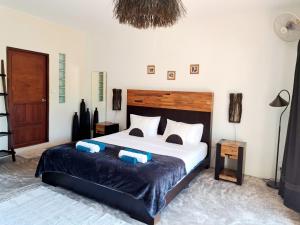 a bedroom with a large bed with two pillows at Laura Guest House Samui in Lamai