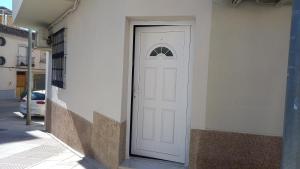 une porte blanche sur le côté du bâtiment dans l'établissement Apartamento turístico Travelers, à Baena