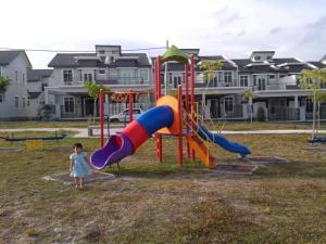 a little girl standing next to a playground at DAlyaHomestay in Malacca