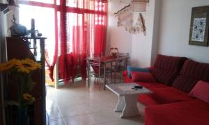 プラヤ・デ・ラス・アメリカスにあるTorres Yomelyのリビングルーム(赤いソファ、テーブル付)