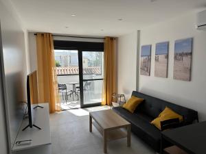 a living room with a black couch and a table at APARTAMENTOS LA CALA de MIJAS in La Cala de Mijas