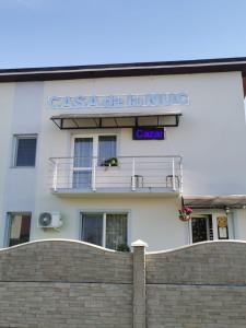 un bâtiment blanc avec une clôture devant lui dans l'établissement Casa de la Nuc, à Târgu Jiu