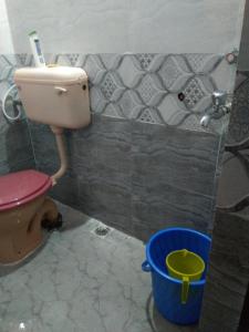 a bathroom with a toilet and a blue bucket at Garden Villa, Hyderabad in Hyderabad +37 photos
