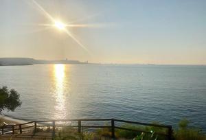 - une vue sur une grande étendue d'eau avec le soleil dans l'établissement Governors Beach Panayiotis, à Plage du Gouverneur