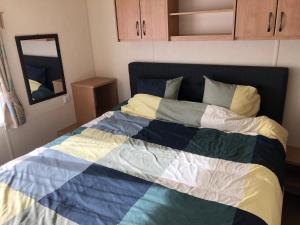 Una cama con una manta de colores en una habitación en chalet, en Kropswolde