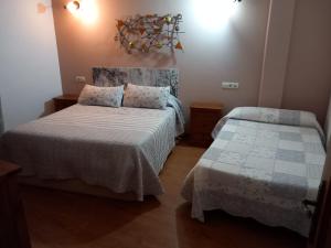 a bedroom with two beds in a room at Casa Rural La Fuente in Tejedo del Sil