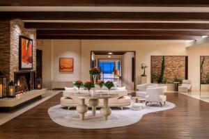 uma sala de estar com mobiliário branco e uma lareira em The Ritz-Carlton, Rancho Mirage em Rancho Mirage