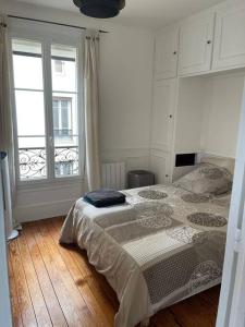 1 dormitorio con cama y ventana grande en Parisien style T2 in center of Puteaux, en Puteaux