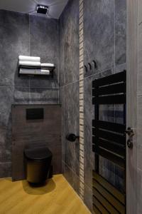 a bathroom with a black toilet and some towels at Signature Apartments in Blackpool