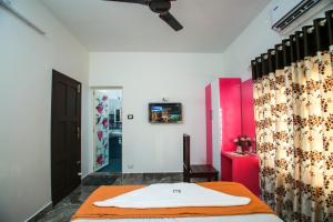 a room with a bed and a tv on the wall at BIJIS HOMESTAY in Alleppey