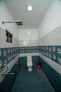 a bathroom with a toilet and blue and white tiles at BIJIS HOMESTAY in Alleppey