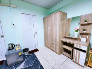 a kitchen with blue walls and wooden cabinets at Homely Home Near BTS Kasetsart U. St. in Bangkok