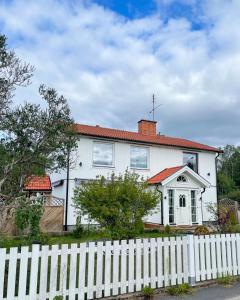 una casa blanca con una valla blanca en Villa Rosenfors, en Rosenfors