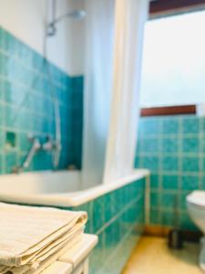 a blue tiled bathroom with a sink and a toilet at B17 Two Bed Apartment West Town in Heidenheim an der Brenz