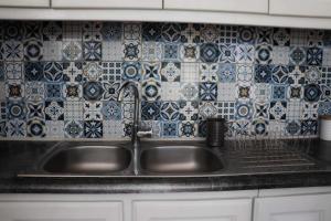 a sink in a kitchen with blue and white tiles at Villa Sevasti in Kardamaina