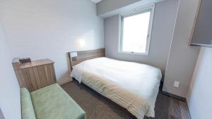 Habitación pequeña con cama y ventana en Super Hotel Tokyo Akabane Eki Minamiguchi en Tokio