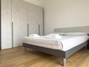 a bedroom with a bed with white sheets and cabinets at Accogliente trilocale a Brescia in Brescia