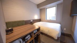 a small bedroom with a bed and a desk at Super Hotel Tokyo Akabane Eki Minamiguchi in Tokyo