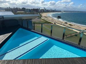 a swimming pool on top of a building with a beach at DNA Dream Home in Durban