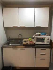 a small kitchen with a sink and a microwave at Beach Palace Condomenium (Chaam-Huanhin) in Ban Bo Khaem