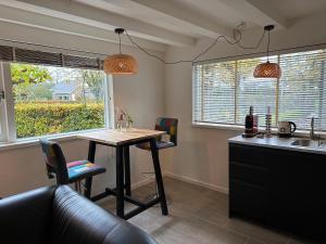 a kitchen with a table and chairs and a sink at Bloemenboerderij Aperloo in Aperloo