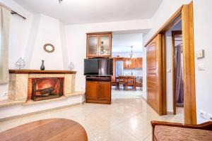 ein Wohnzimmer mit Kamin und eine Küche in der Unterkunft Villa Vasiliki in Vasilikí