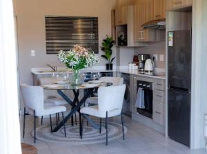 a kitchen with a table and chairs with flowers on it at nile apartment with power backup in Sandton