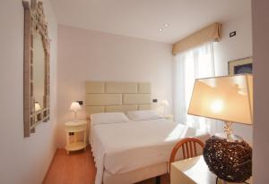 a bedroom with a bed and a table with a lamp at Hotel Florida Lerici in Lerici