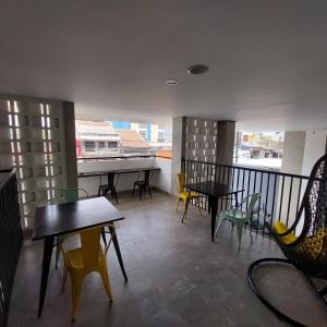 a room with tables and chairs and a balcony at Rumah Gaharu in Bandung