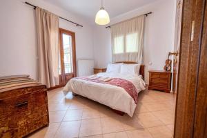 um quarto com uma cama grande e uma janela em Villa Vasiliki em Vasilikí