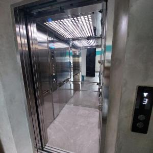 a elevator with a glass door in a building at Rumah Gaharu in Bandung