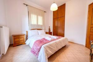 ein Schlafzimmer mit einem großen Bett und einem Holzschrank in der Unterkunft Villa Vasiliki in Vasilikí