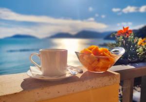 a cup of coffee and a bowl of oranges on a table at Hotel Florida Lerici in Lerici