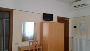 Zimmer mit einem Tisch und einem TV an der Wand in der Unterkunft Hotel Montepiana in Mestre