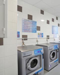 uma lavandaria com uma máquina de lavar roupa e um lavatório em Appart Suites Citadines Access 15 minutes Paris Montparnasse - Metro & Accès facile Paris Parc Expo em Châtillon