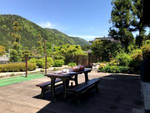 einen Tisch und Bänke auf einer Terrasse mit einem Tennisplatz in der Unterkunft Ohara Chisui - Vacation STAY 9209 in Sakamoto