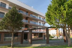 Un edificio de apartamentos con árboles en frente. en Consolação & Supertubos - Beach House II, en Atouguia da Baleia