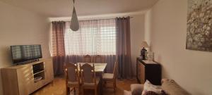 uma sala de estar com uma mesa de jantar e uma televisão em Apartament TRINI em Klodzko